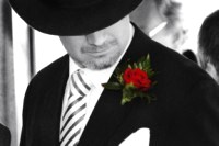 Groom looking at a red rose
