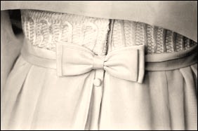 Detail of a white wedding dress from behind with a bow
