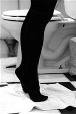 Legs of a girl in front of a toilet