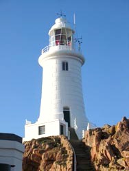 A white lighthouse on top of a rock