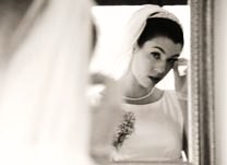 Bride adjusting her makeup in front of a mirror