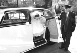 A bride getting off a wedding car hire.