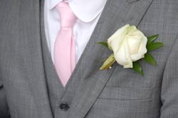 A groom wearing wedding flowers