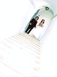 A bride and a groom coming down a staircase
